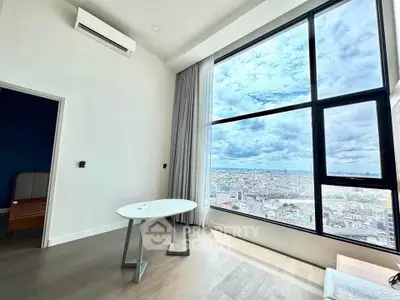 Modern living room with stunning city view through large windows, featuring minimalist furniture and air conditioning.