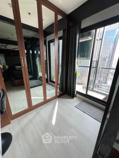 Modern bedroom with mirrored closet and city view balcony