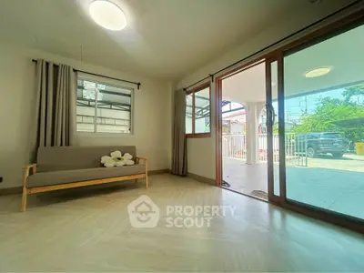 Spacious living room with sliding glass doors leading to a sunny patio and garden view.