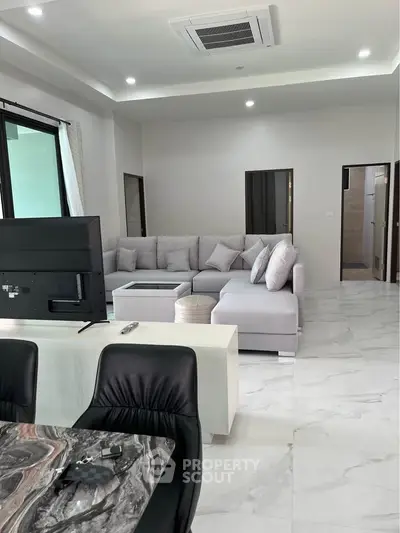 Spacious modern living room with elegant marble flooring and stylish furniture