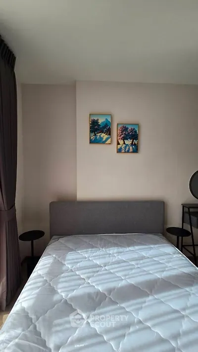 Cozy bedroom with modern decor and natural light, featuring a comfortable bed and stylish artwork.