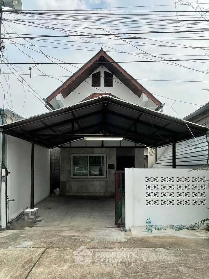 Charming two-story house with covered driveway and traditional roof design.