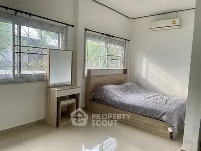Bright bedroom with large windows and modern furnishings in a cozy home.