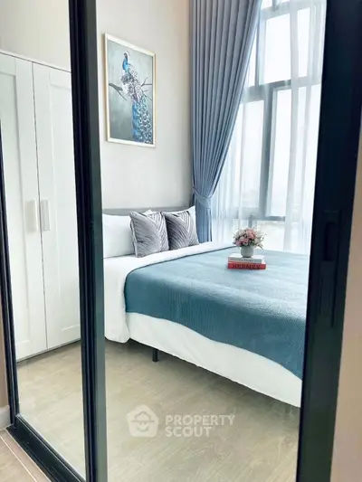 Modern bedroom with large window, elegant decor, and stylish furnishings.