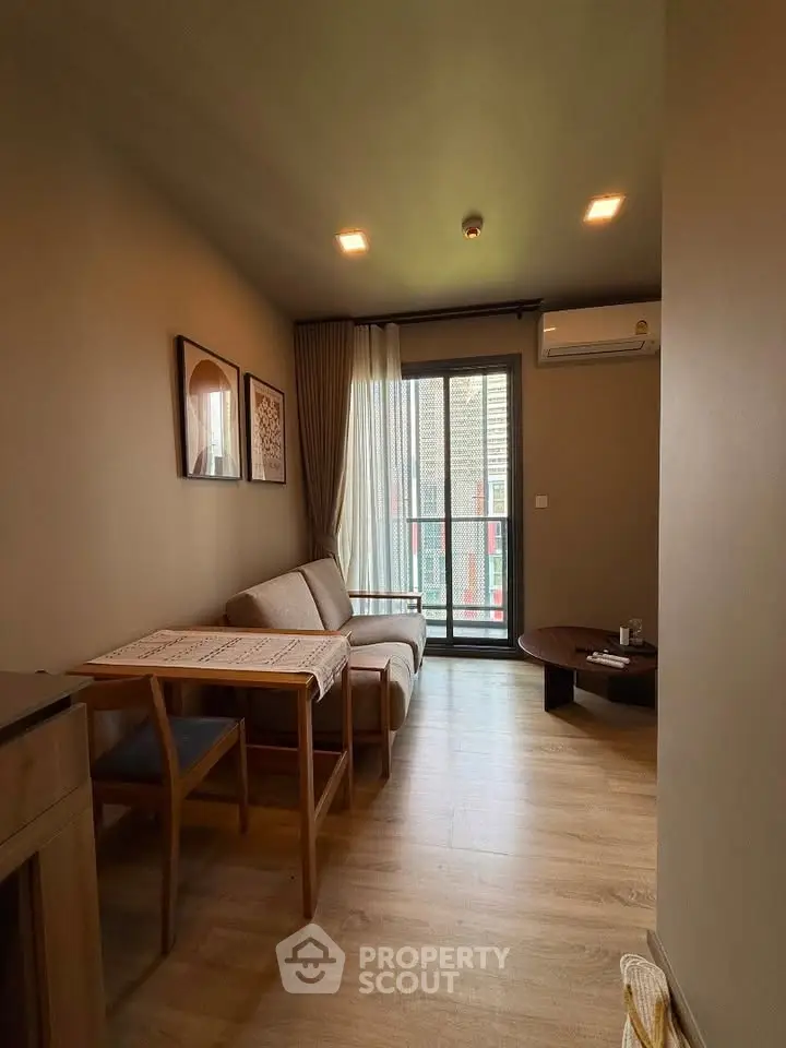 Cozy living room with modern decor and balcony access in a stylish apartment.