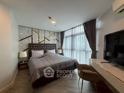 Luxurious bedroom with elegant decor and large window offering natural light.
