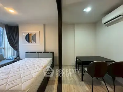 Modern studio apartment with cozy bedroom and dining area, featuring stylish decor and natural light.