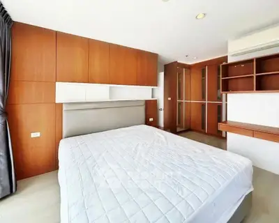 Spacious modern bedroom with wooden accents and ample storage space