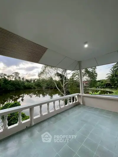 Spacious balcony with serene river view, perfect for relaxation and enjoying nature.