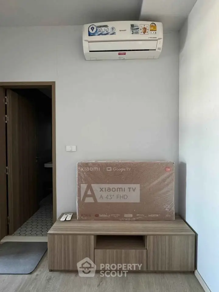 Modern living room with air conditioning and new Xiaomi TV setup, showcasing sleek furniture design.