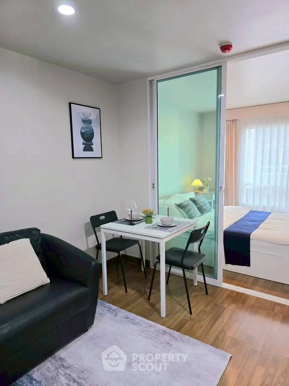 Modern studio apartment with cozy living area and stylish bedroom, featuring sleek furniture and elegant decor.