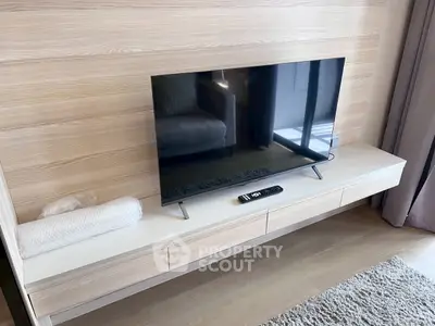 Modern living room with sleek TV setup and stylish wooden paneling.