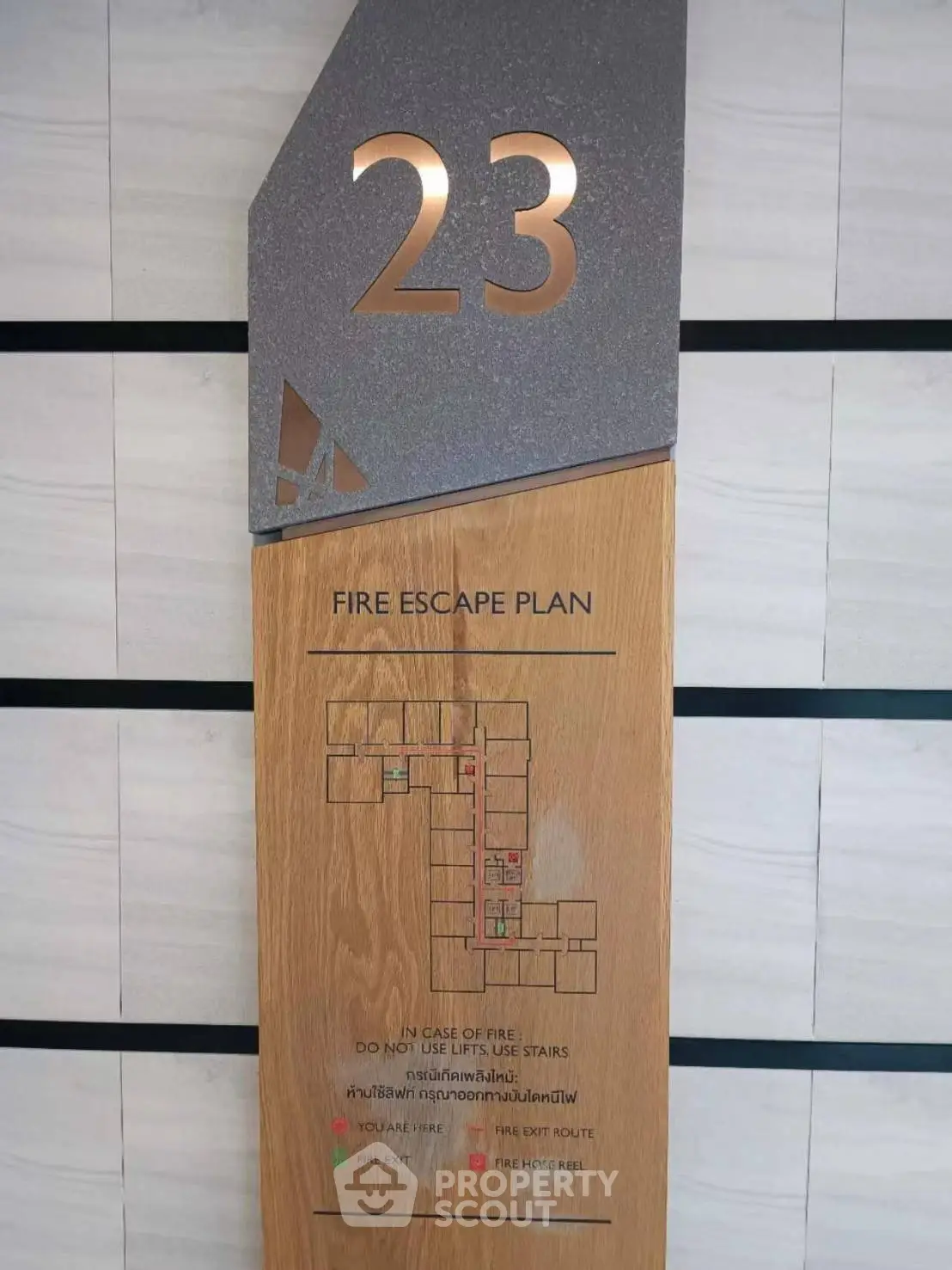 Modern fire escape plan on wooden panel for high-rise building safety.