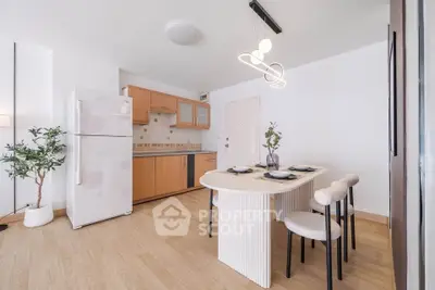 Modern kitchen with dining area, featuring sleek wooden cabinets and contemporary lighting.