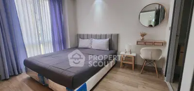 Modern bedroom with stylish decor and natural light, featuring a comfortable bed and elegant furnishings.