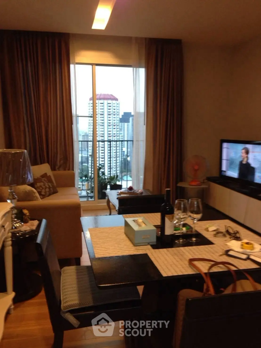 Modern living room with city view, stylish furniture, and cozy dining area, perfect for urban living.