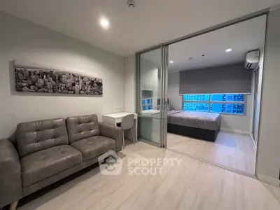 Modern apartment with sleek living room and cozy bedroom, featuring a cityscape artwork and large windows.