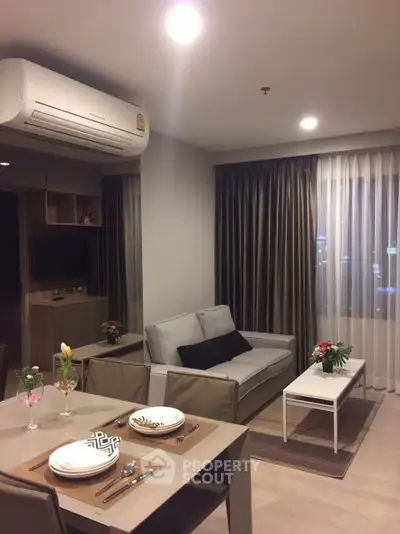 Modern living room with cozy sofa, dining area, and elegant decor in a stylish apartment.