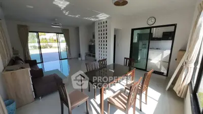 Spacious dining area with modern furniture and open kitchen layout, perfect for family gatherings.