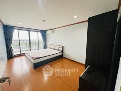 Spacious bedroom with large windows and wooden flooring offering a stunning view.