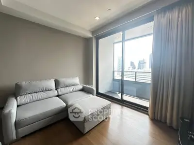 Modern living room with sleek sofa and city view balcony in high-rise apartment.