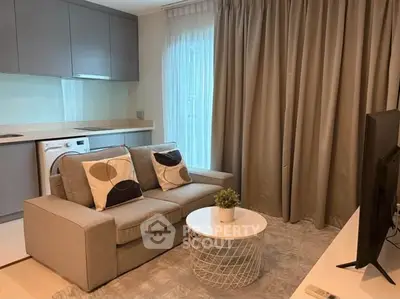 Modern living room with cozy sofa, stylish decor, and integrated kitchen appliances.