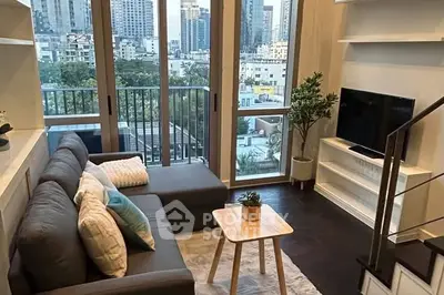 Modern living room with city view, cozy sofa, and stylish decor in urban apartment.
