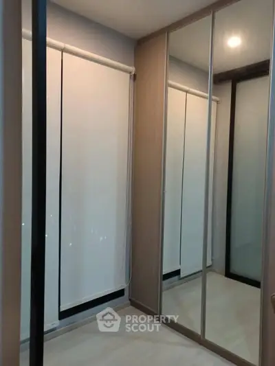 Modern bedroom with mirrored wardrobe and sleek window blinds