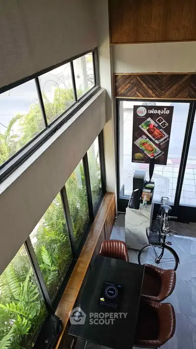 Modern cafe interior with large windows and stylish seating, perfect for a cozy dining experience.