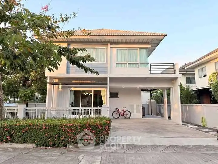 Charming two-story house with spacious driveway and lush greenery in a serene neighborhood.