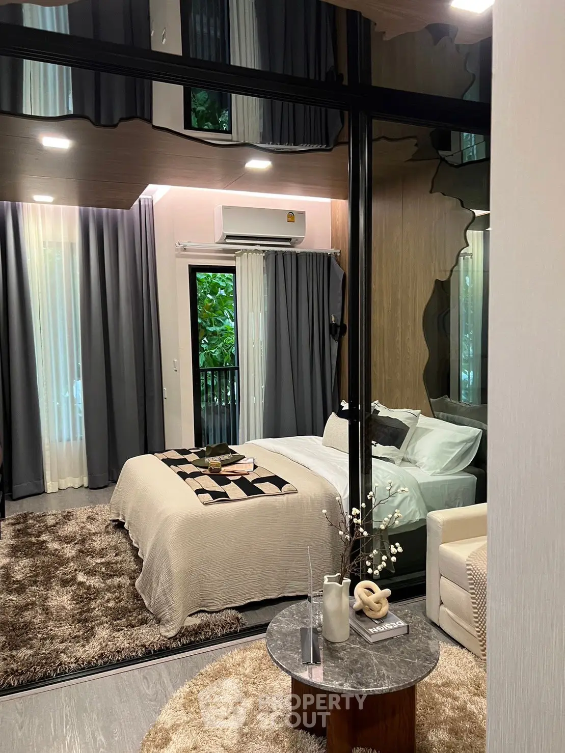 Luxurious bedroom with modern decor and large windows overlooking greenery, perfect for relaxation.