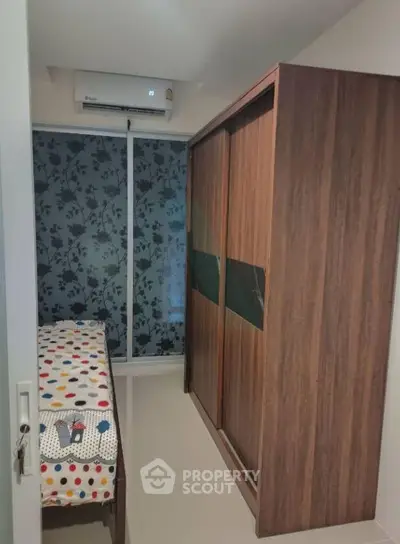 Cozy bedroom with modern wardrobe and air conditioning, perfect for comfortable living.
