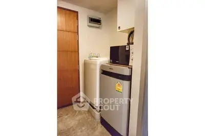 Compact laundry area with washing machine and dryer in modern apartment.