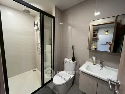 Modern bathroom with sleek design, glass shower enclosure, and stylish fixtures.
