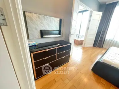Spacious bedroom with elegant wooden flooring and modern furniture