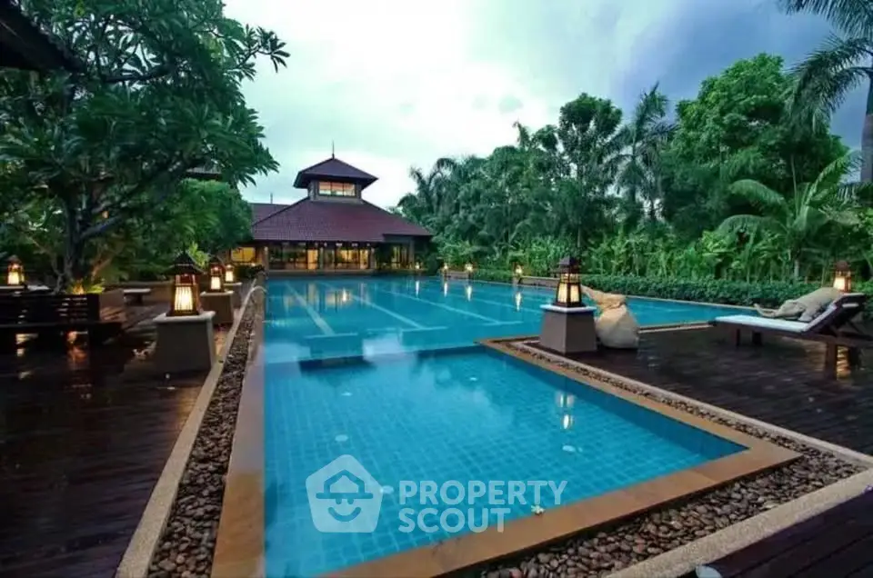 Luxurious tropical resort pool with lush greenery and elegant architecture, perfect for relaxation and leisure.