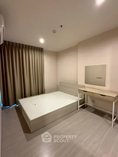 Spacious bedroom with modern minimalist design and ample natural light.