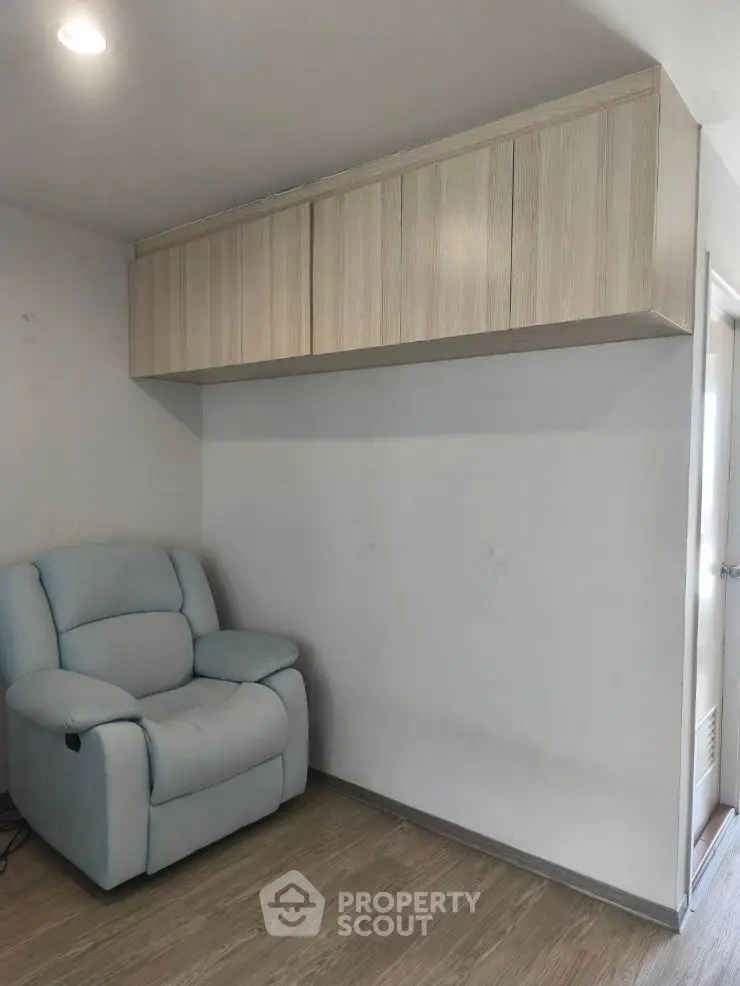 Cozy study nook with armchair and overhead storage cabinets
