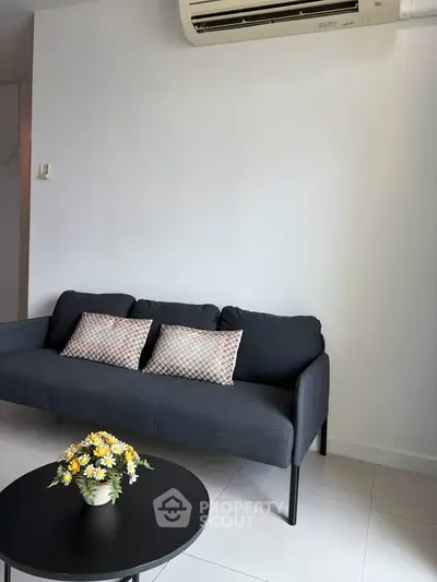 Modern living room with sleek sofa and air conditioning, perfect for relaxation.