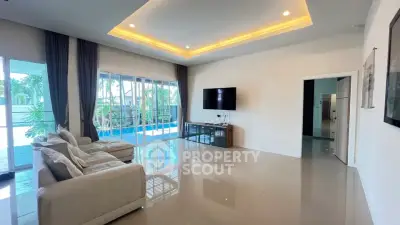 Spacious modern living room with pool view and elegant lighting