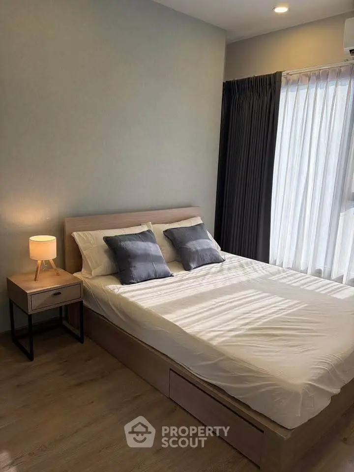 Modern bedroom with natural light, cozy bed, and stylish decor in a contemporary apartment.