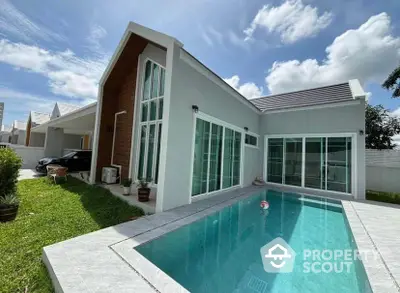 Modern single-story house with private pool and lush garden under a clear blue sky.