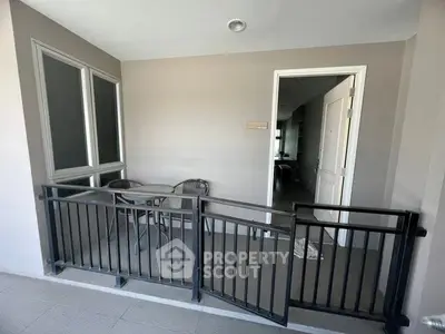 Charming balcony space with cozy seating area and modern railing design.