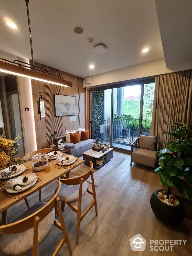 Modern living room with dining area and balcony view, featuring stylish decor and natural light.