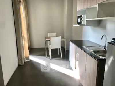 Modern kitchen with sleek cabinetry and dining area in a bright apartment