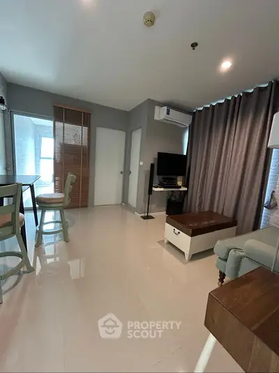 Modern living room with sleek design, featuring a TV, air conditioning, and stylish furniture.
