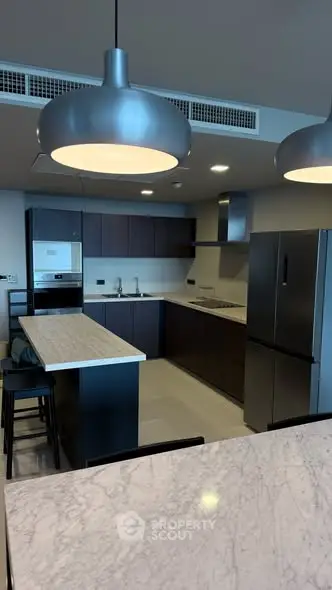 Modern kitchen with sleek design, featuring stainless steel appliances and elegant lighting.