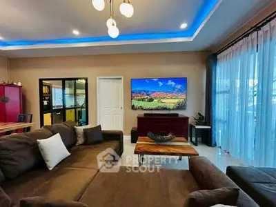 Spacious living room with modern decor and large TV, featuring cozy brown sofa and stylish lighting.