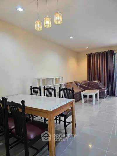 Spacious living room with modern dining area and elegant lighting, perfect for family gatherings.