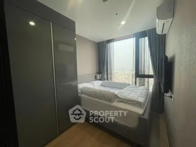 Modern bedroom with city view, featuring sleek wardrobe and air conditioning.
